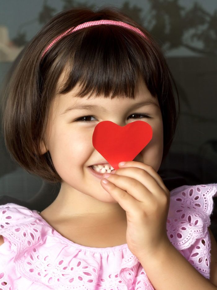 Little girl holding a red heart
