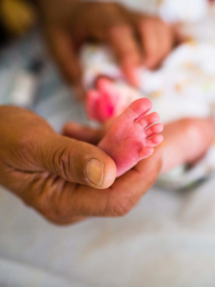 An infant foot being held in a doctor's hand
