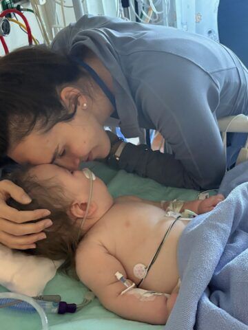 Mom cradles young child in CHOC hospital bed.