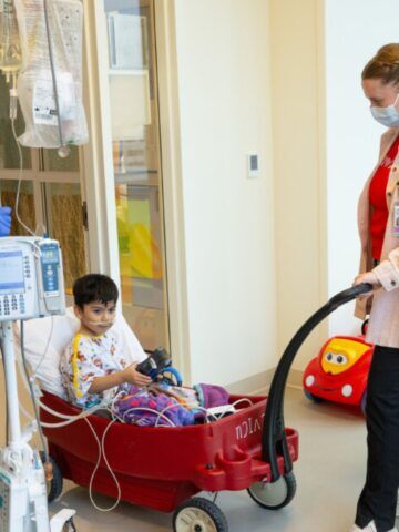 Young heart patient in wagon with a nurse