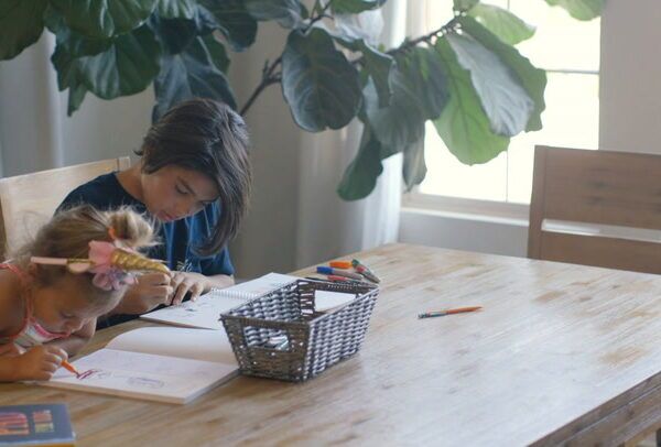 boy and girl at table using pens and colors
