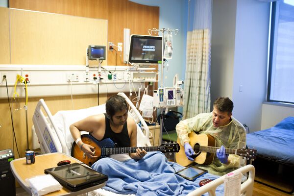 Patient and music therapist playing guitar