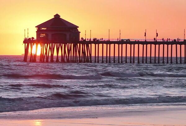 image of a pier over the ocean at sunset