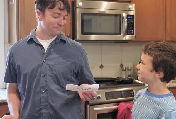 child handing father a note
