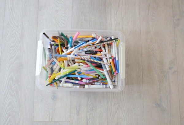 a box of pens and crayons