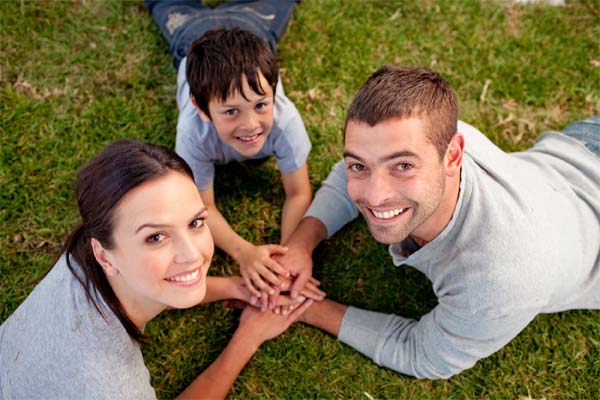 family on grass holding hands