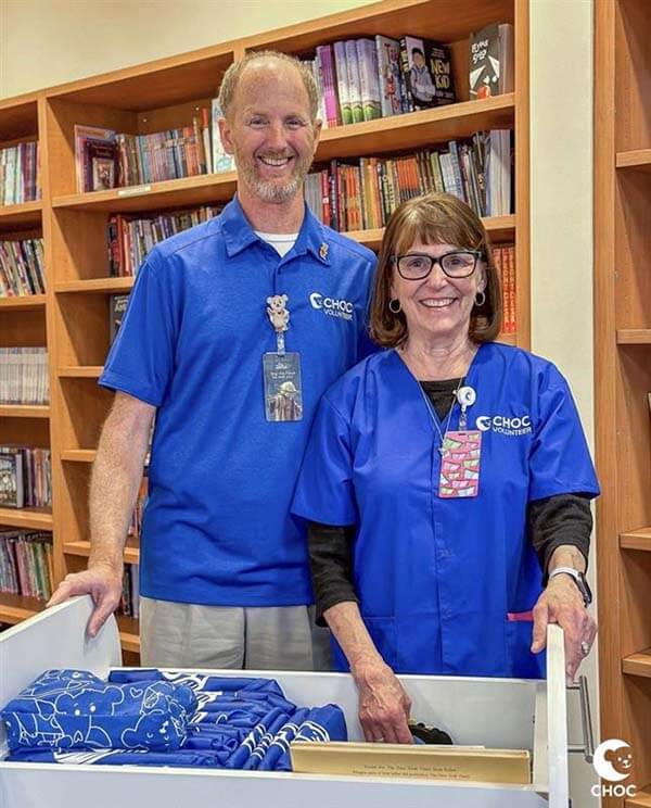 Male and female volunteers posing in resource center