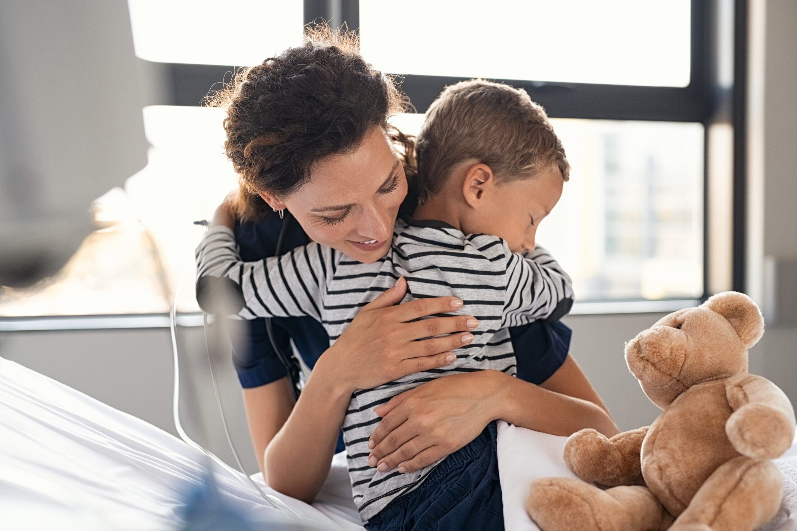 nurse providing comfort and hugging pediatric patient
