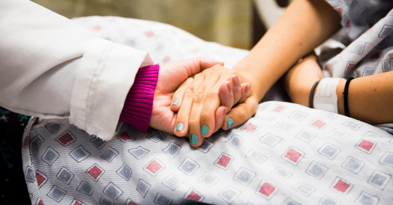 doctor and patient holding hands