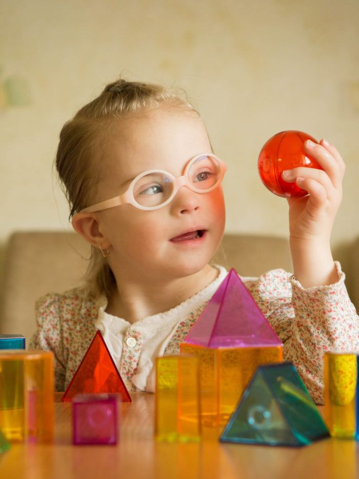 Girl with Down syndrome playing with geometrical shapes