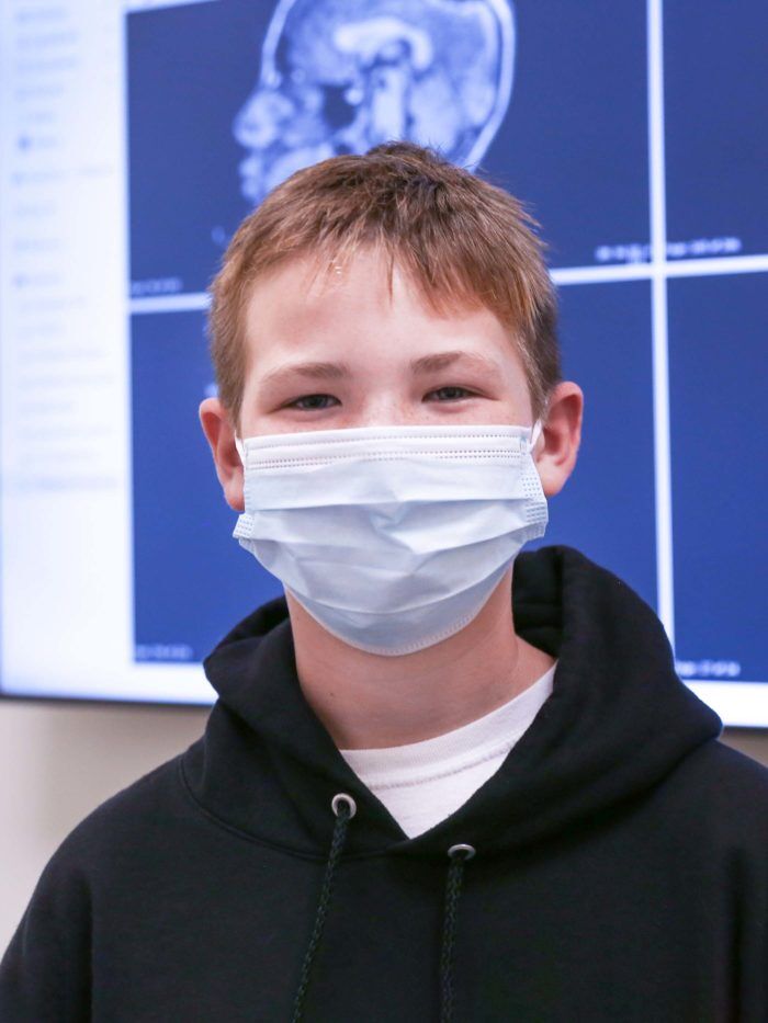 Bryce standing in front of his brain scans