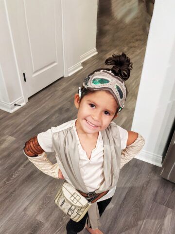 Camila smiles while wearing her cochlear implants and a Disney costume