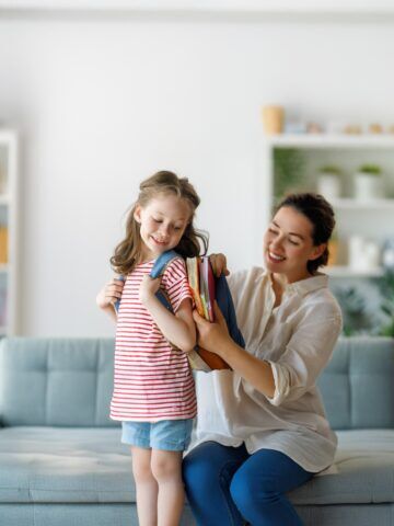 Happy family preparing for school. Little girl with mother.